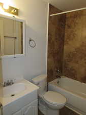 Full bathroom with toilet, tile patterned flooring, tiled shower / bath, and vanity