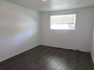 Unfurnished room featuring dark hardwood / wood-style flooring