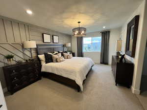 Carpeted bedroom featuring a chandelier