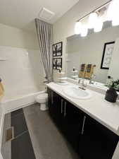 Full bathroom with toilet, vanity, shower / bath combo, and tile patterned flooring