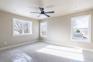 Carpeted spare room with ceiling fan