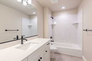 Full bathroom featuring toilet, vanity, and tiled shower / bath