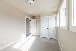 Unfurnished bedroom featuring light colored carpet and a closet