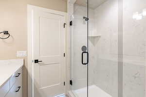 Bathroom featuring vanity and a shower with door