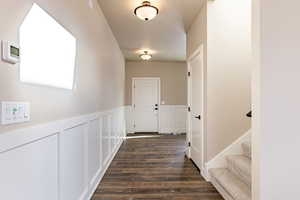 Hallway with dark hardwood / wood-style flooring