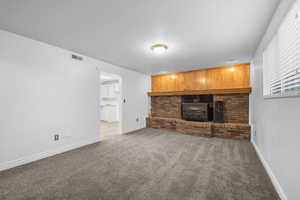 Unfurnished living room featuring a wood stove and carpet flooring