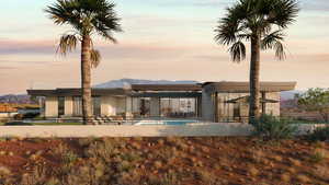 Back house at dusk featuring a patio area and a mountain view