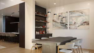 Bar featuring pendant lighting, light hardwood / wood-style flooring, and sink