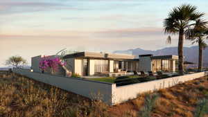 Back house at dusk featuring a mountain view and a patio