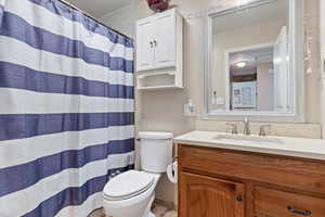 Bathroom featuring toilet, vanity, and walk in shower