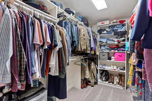 Walk in closet with light colored carpet