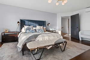 Bedroom featuring dark hardwood / wood-style floors and a wall unit AC