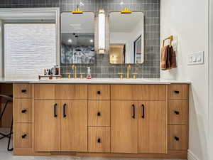 Bathroom featuring vanity and decorative backsplash