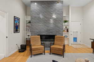 Living area featuring a fireplace, built in features, and hardwood / wood-style flooring