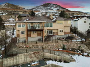 Snow covered house with a mountain view and a balcony