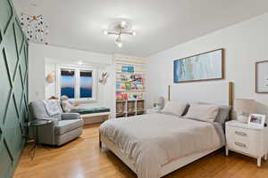 Bedroom featuring light wood-type flooring and an inviting chandelier