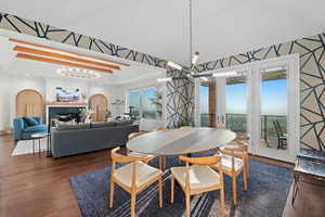 Dining room with dark hardwood / wood-style floors, crown molding, and an inviting chandelier