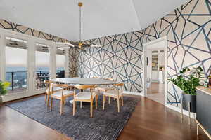 Dining space featuring wood-type flooring and vaulted ceiling