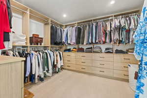 Walk in closet with light carpet