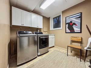 Washroom with washing machine and dryer and cabinets