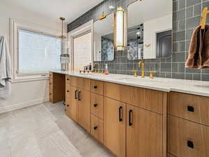 Bathroom with tile patterned flooring, vanity, and decorative backsplash