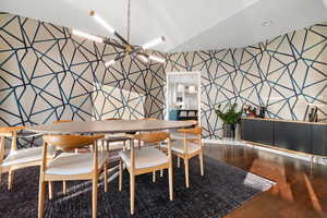 Dining room featuring wood-type flooring and an inviting chandelier