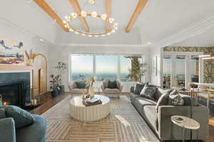 Living room featuring hardwood / wood-style flooring, a tray ceiling, ornamental molding, and an inviting chandelier