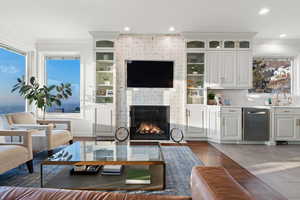 Living room featuring crown molding, a fireplace, hardwood / wood-style flooring, and sink