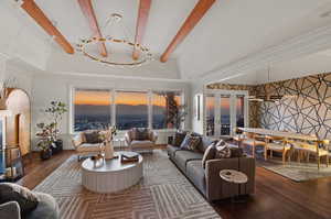 Living room featuring dark hardwood / wood-style flooring, beam ceiling, french doors, and ornamental molding