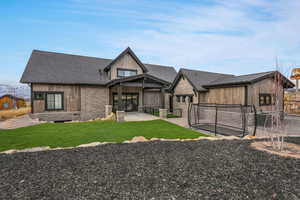 Back of property featuring a trampoline, a patio, and a yard