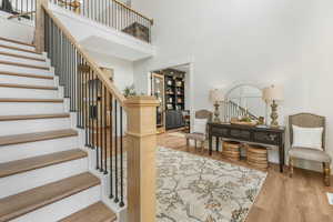 Interior space with a towering ceiling and hardwood / wood-style flooring