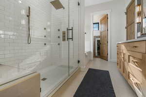 Bathroom featuring separate shower and tub, vanity, and tile patterned flooring