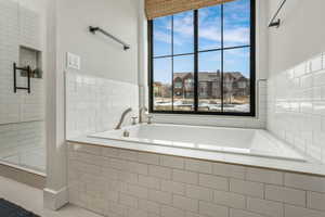 Bathroom featuring tile patterned flooring and a relaxing tiled tub