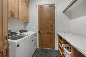 Laundry room featuring cabinets and washing machine and dryer