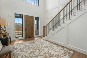 Foyer with a towering ceiling and hardwood / wood-style floors