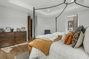 Bedroom featuring light hardwood / wood-style flooring and a raised ceiling