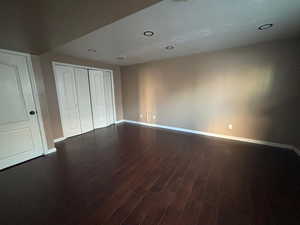 Bedroom with a closet and dark hardwood / wood-style floors