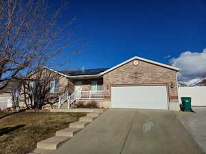 View of front facade with a garage and solar panels