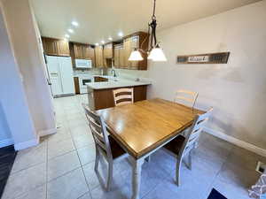 Tiled dining area with sink and a notable chandelier