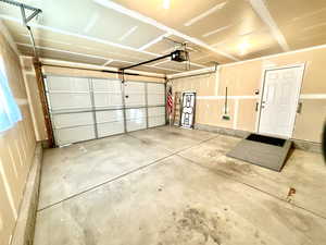 Two car garage with sideyard door, window and accessibility ramp.