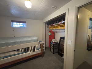 Bedroom featuring carpet floors, a closet, and a textured ceiling