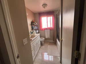 Full bathroom with toilet, vanity, tile patterned flooring, and shower / bath combination