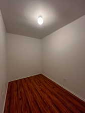 Empty room with dark wood-type flooring