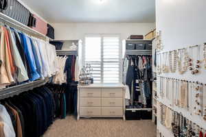 Walk in closet with light carpet