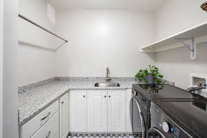 Laundry room with cabinets, sink, and separate washer and dryer