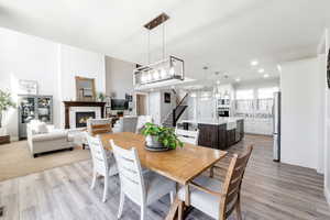 Dining room with light wood-type flooring and a fireplace