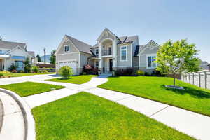 View of front of house with a front lawn, a balcony, and a garage