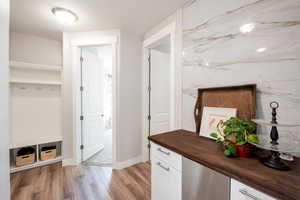 Mudroom with a textured ceiling and light wood-type flooring