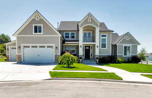 Craftsman house with a garage and a front lawn