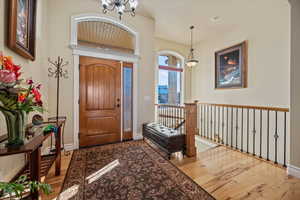 Entryway with hardwood / wood-style flooring and a notable chandelier